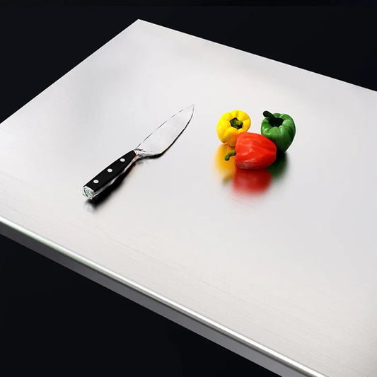 White cutting board with a knife and colorful peppers on a black background